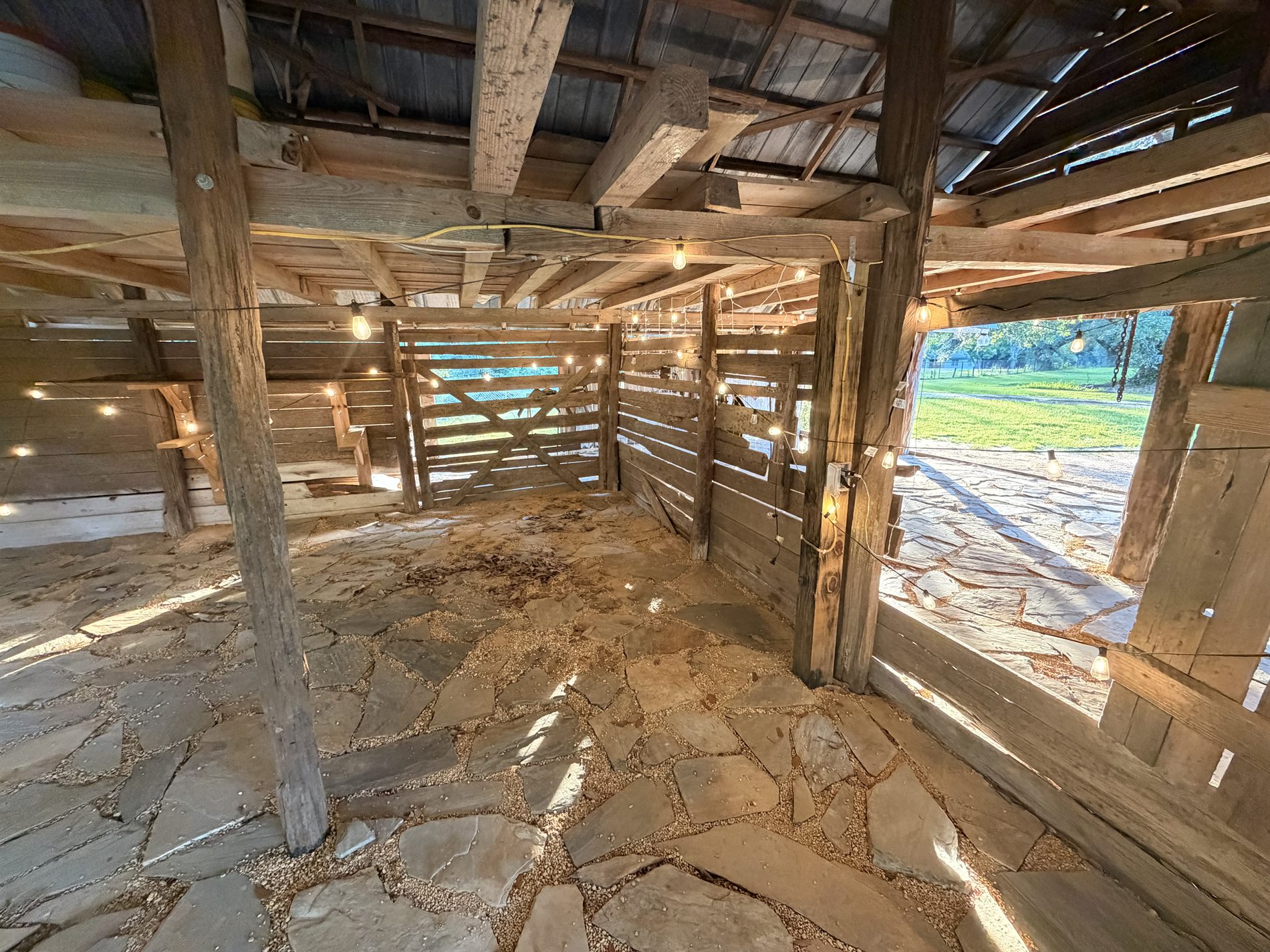 Historic barn interior event space with original cypress timber and flagstone floor in South Alabama
