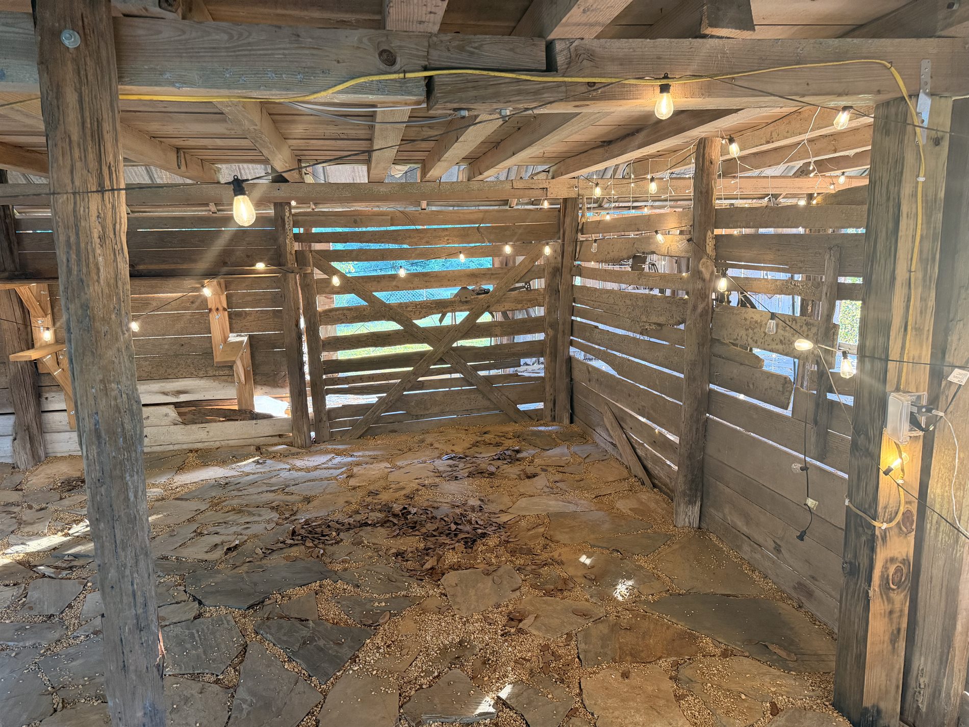Historic barn interior with flagstone floor and string lights