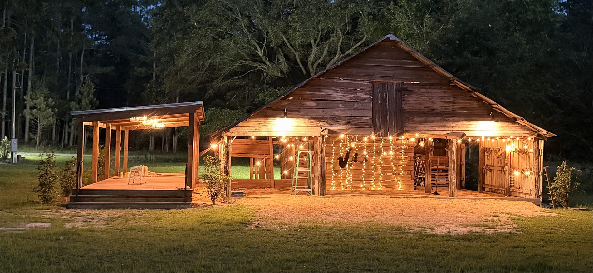 Historic cypress barn with string lights at night for South Alabama outdoor events