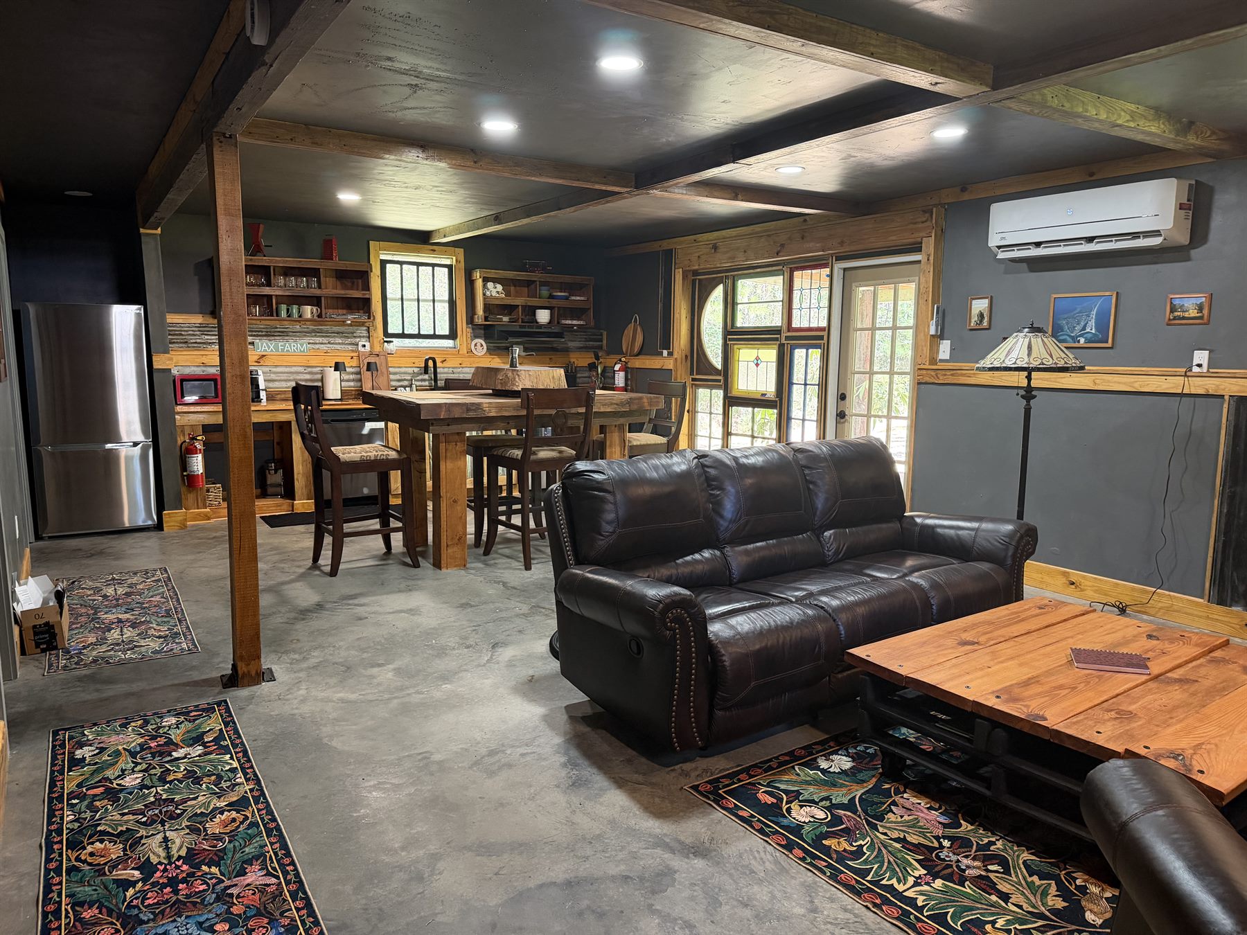 Cabin interior living room, kitchen, custom wood table and air conditioning at Rustic JaxFarm