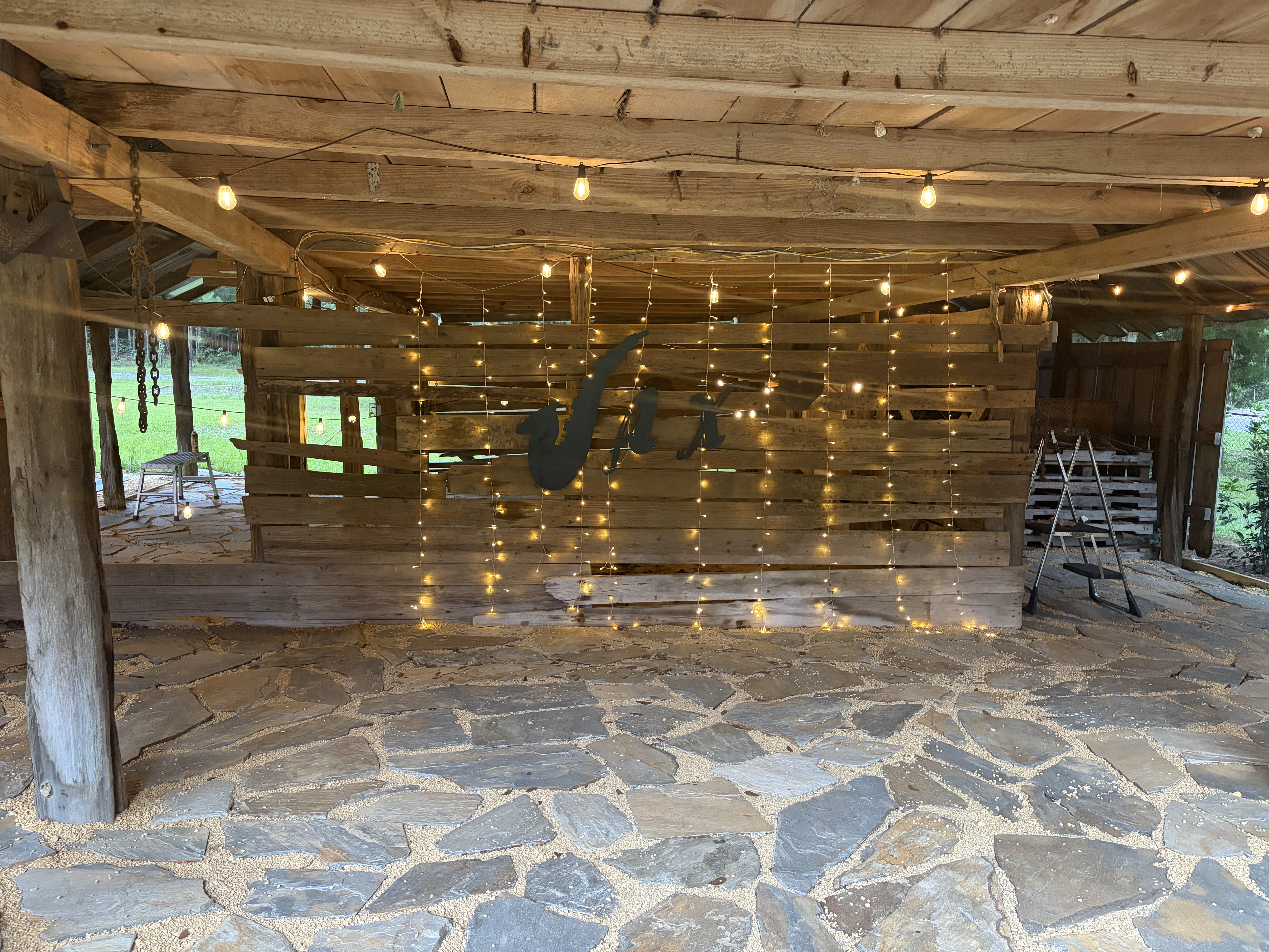 Historic barn interior with flagstone floor and string lights