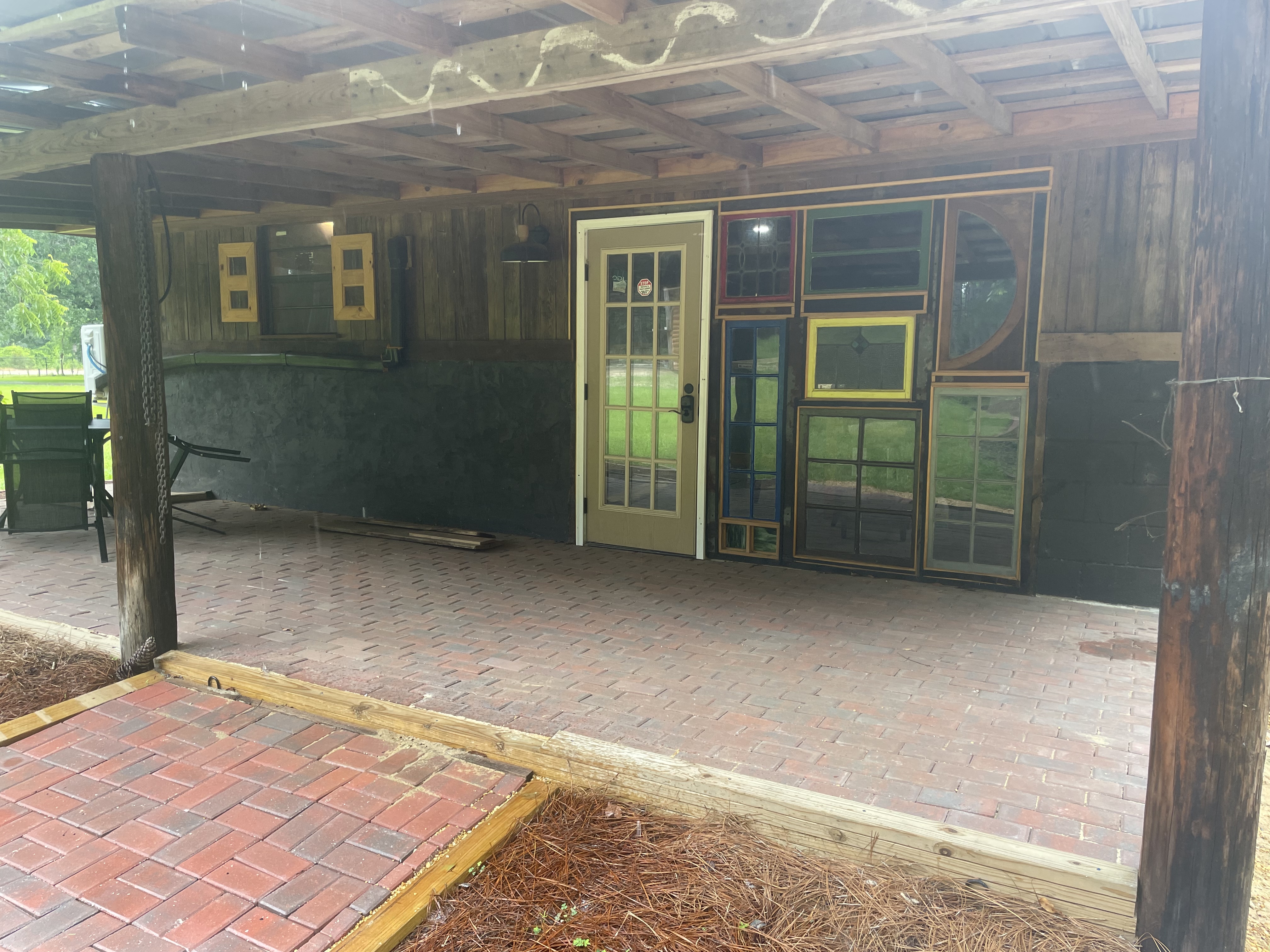 Covered barn area with brick floor and colorful cabin doors