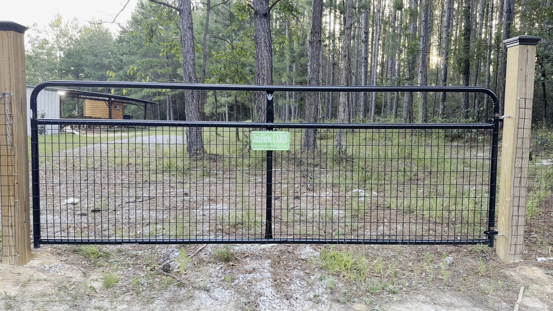 Rustic JaxFarm front gate video still with wooded South Alabama entrance