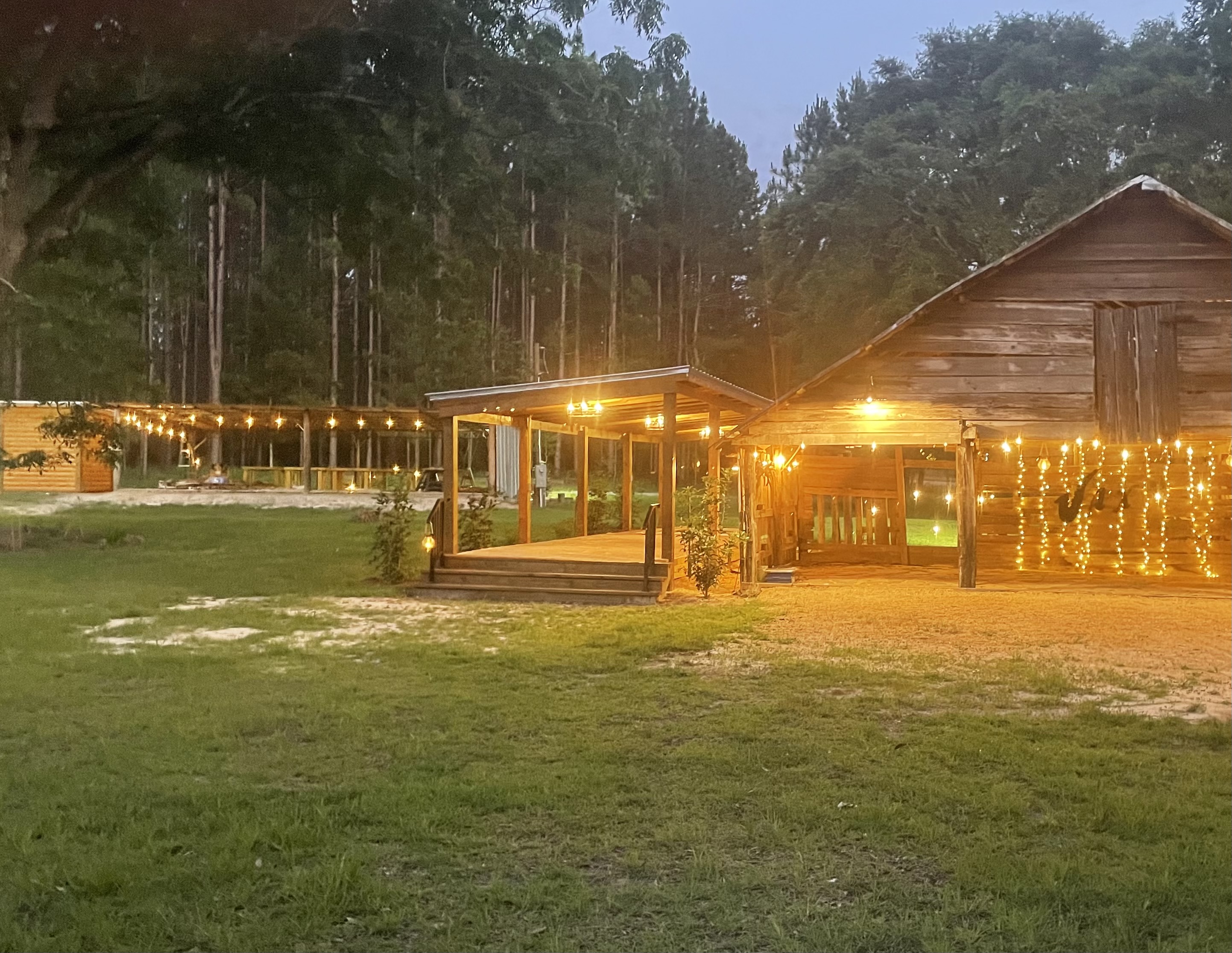 Pergola and historic barn with string lights for rustic South Alabama weddings